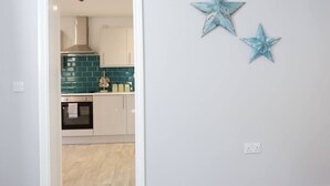 Uma cozinha com azulejos verde-água, um fogão e duas estrelas decorativas na parede.