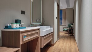 A modern bathroom with a large mirror, dual sinks, and a wooden vanity.