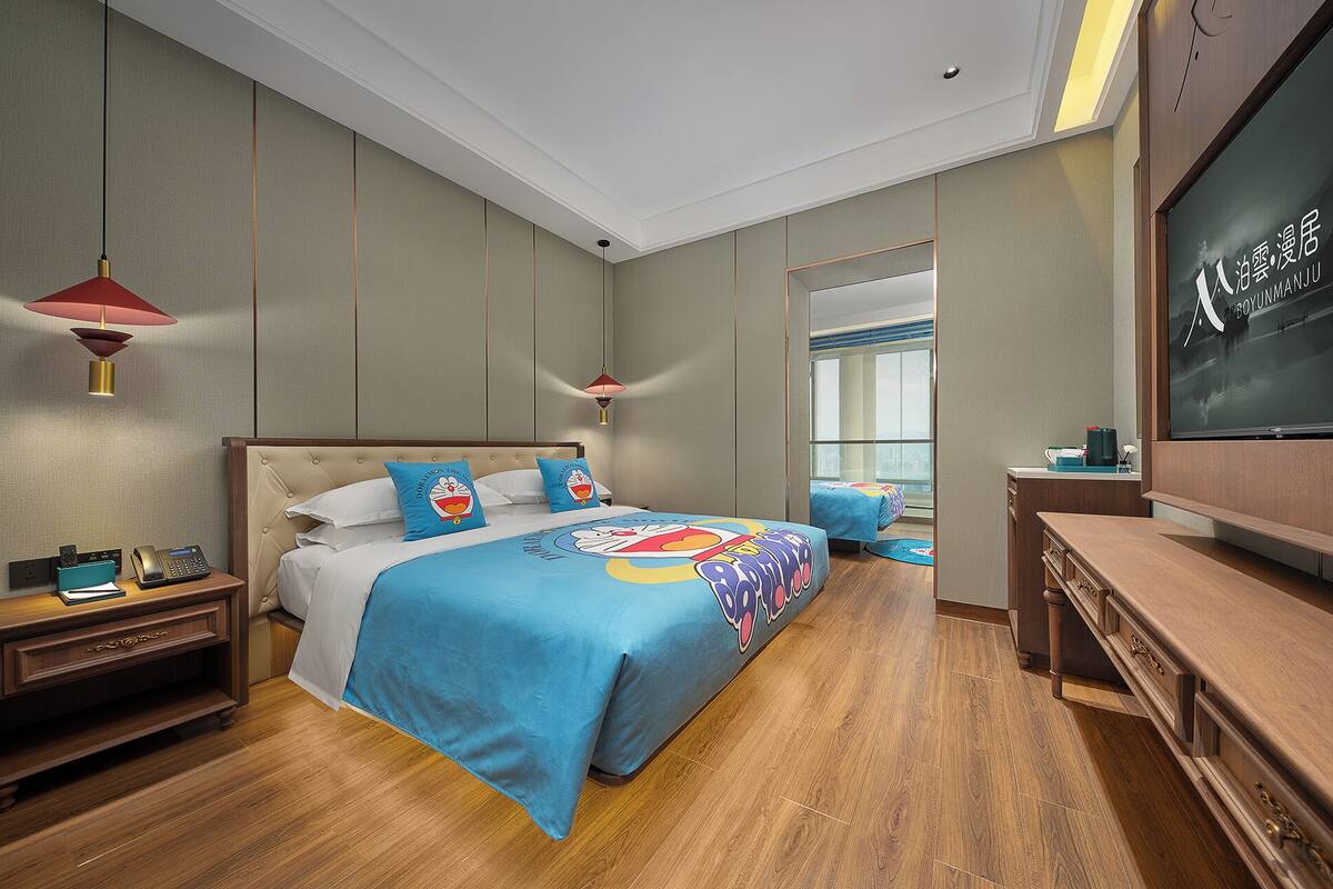 Une chambre d’hôtel avec un lit, des tables de chevet, une télévision et une vue sur l’extérieur.