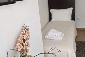 A hotel room with a bed, a neatly folded towel, and a wall-mounted plant. - Land - oak house (Outeiro da Ribeira)