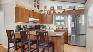 A kitchen with wooden cabinets, a stainless steel refrigerator, a microwave, and a coffee maker. - *Amazing 3BD w/ Hot Tub | Fire Pit + Pool Access* (Gatlinburg)