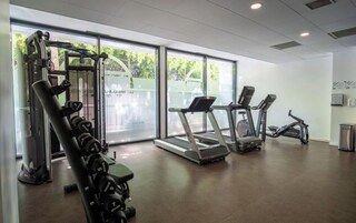 A gym with treadmills, a weight bench, and a squat rack.