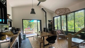 Una cocina moderna con comedor, una escalera y vistas al exterior.