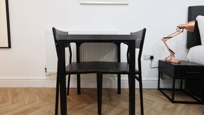 A room with a dark wooden desk, a chair, a lamp, and a radiator. - Contractor Studio • Parking • Smart TV & Kitchen (Pontardawe)
