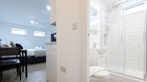 A modern bathroom with a glass shower enclosure, a white toilet, and a white sink. - Contractor Studio • Parking • Smart TV & Kitchen (Pontardawe)
