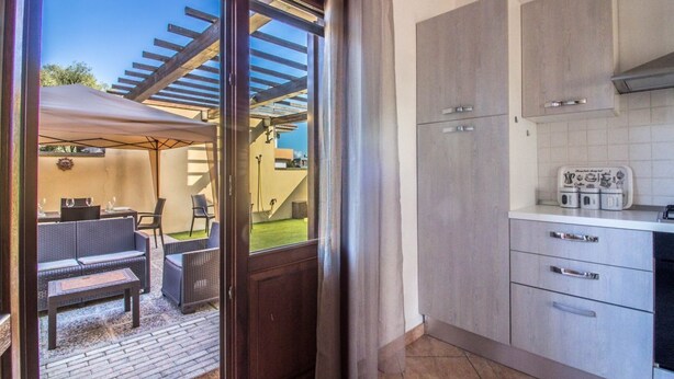 A kitchen with modern appliances and a dining area with outdoor furniture. - GuestHost - A bright and welcoming 68 square meters apartment, perfect for four people, with a private entrance on the ground floor.The property is located in a quiet area of ​​Olbia and is close to all the main amenities, including restaurants, bars (Olbia)