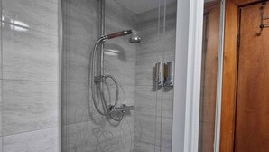 A shower with a handheld showerhead and a wall-mounted faucet, a wooden door, and a tiled wall. - Single Room • Fridge • Microwave • Parking (Pontardawe)