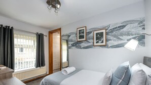 A hotel room with a bed, bedside table, and a window with curtains. - Single Room • Fridge • Microwave • Parking (Pontardawe)
