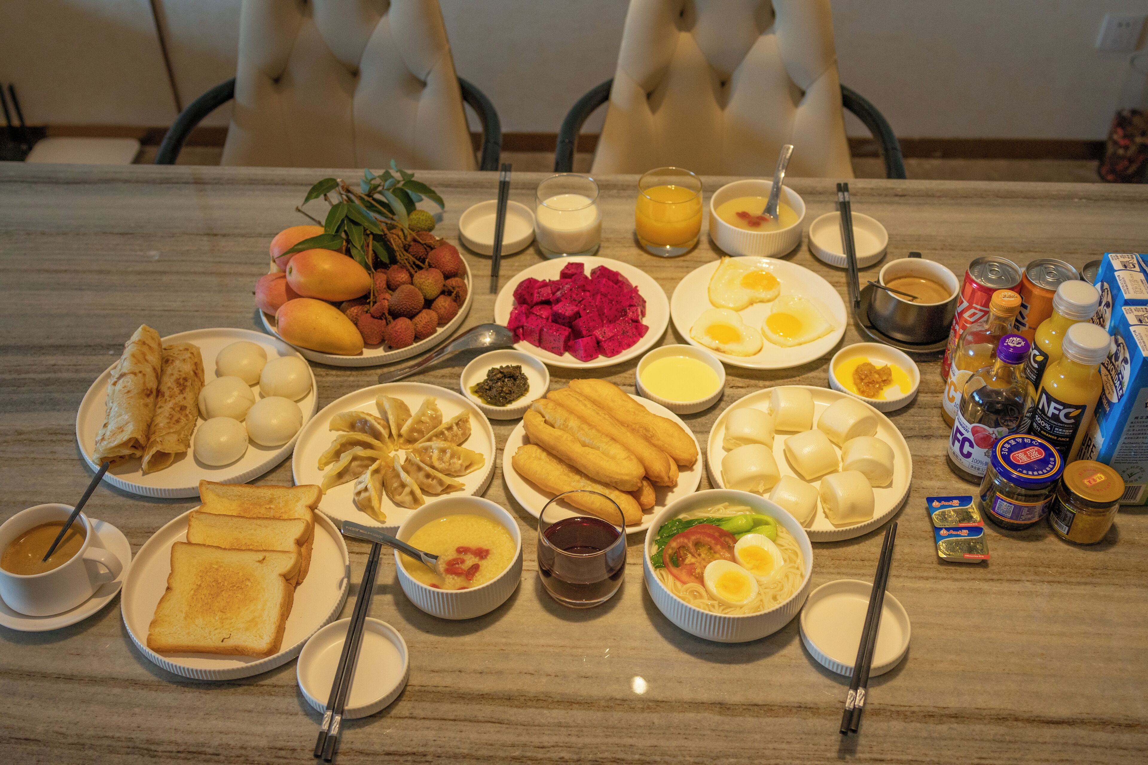 A dining table with various dishes, including eggs, meat, and vegetables, and a variety of condiments and beverages.