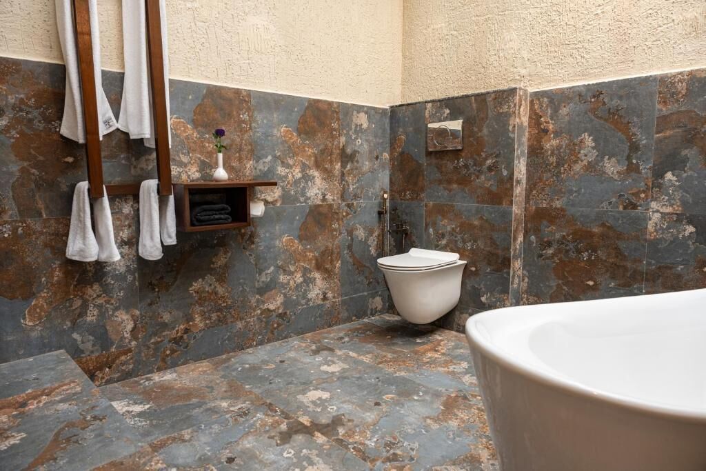 A bathroom with a bathtub, a toilet, and a towel rack.