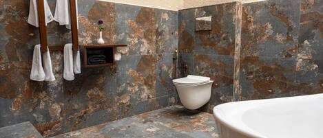 A bathroom with a bathtub, a toilet, and a towel rack.