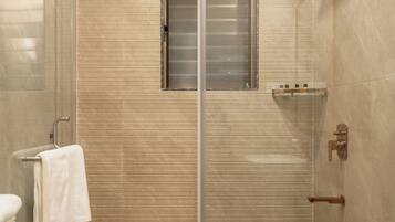 Une salle de bain moderne avec une douche à parois de verre, des toilettes et un porte-serviettes.