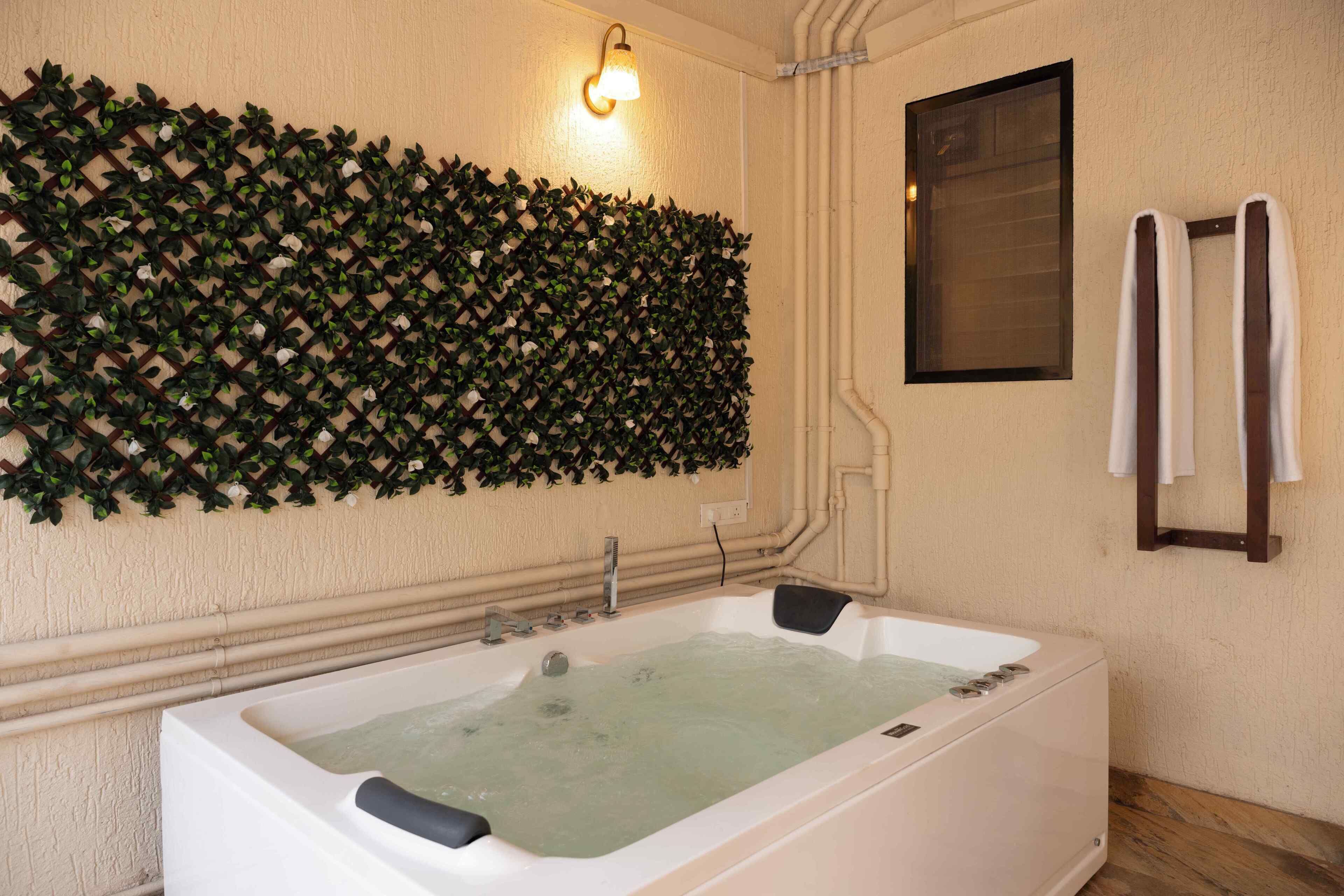 A spa room with a large bathtub, a wall-mounted light fixture, and a towel rack.