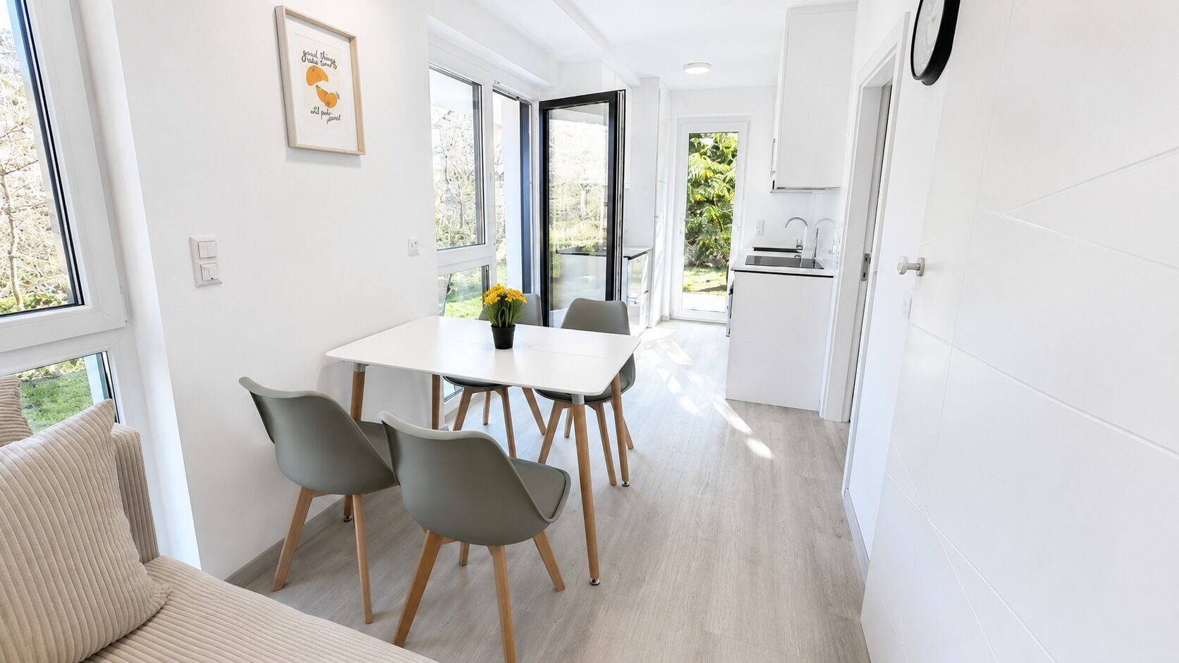 A modern kitchen with white cabinets, a sink, and a window.