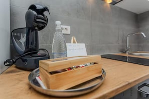A modern kitchen with a coffee machine, a water bottle, and a wooden box on the counter. - Zadar Seaside Getaway for 5 (Zadar)