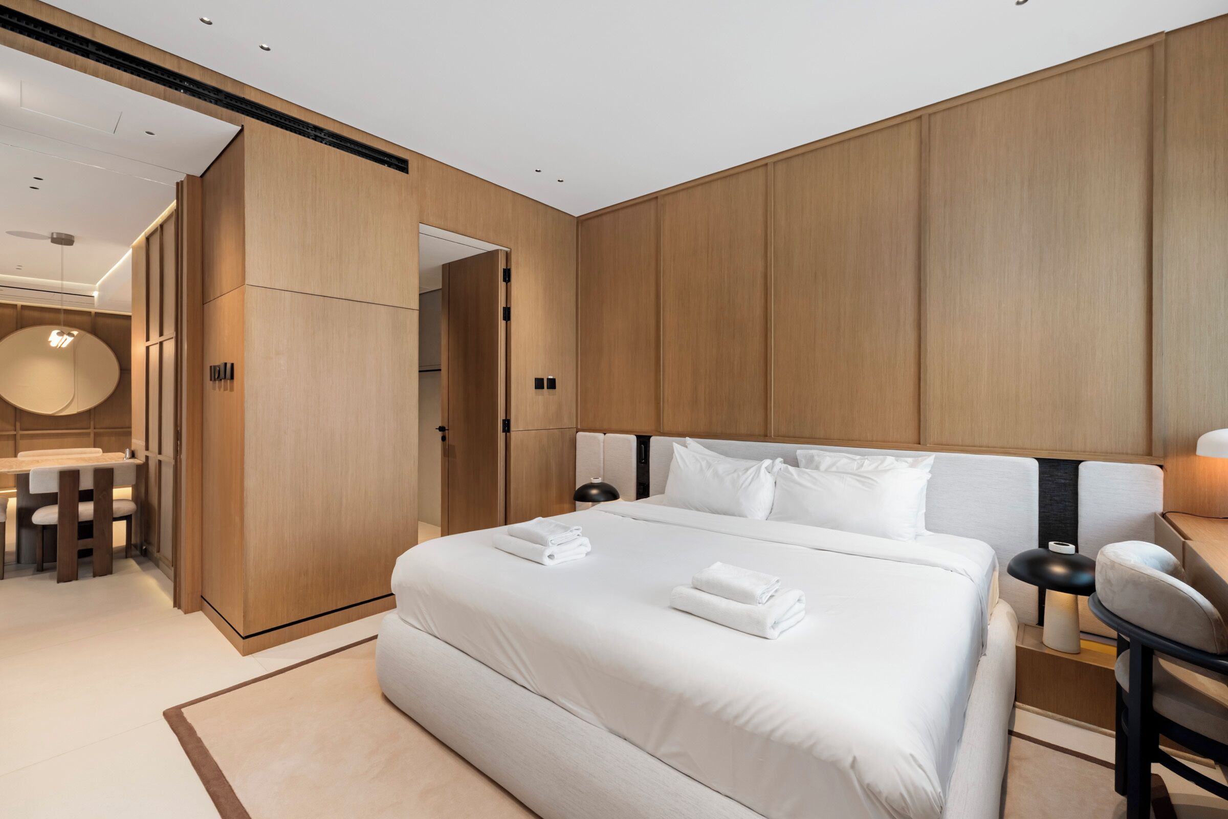 Una habitación de hotel moderna con una cama grande, un escritorio y un baño separado.