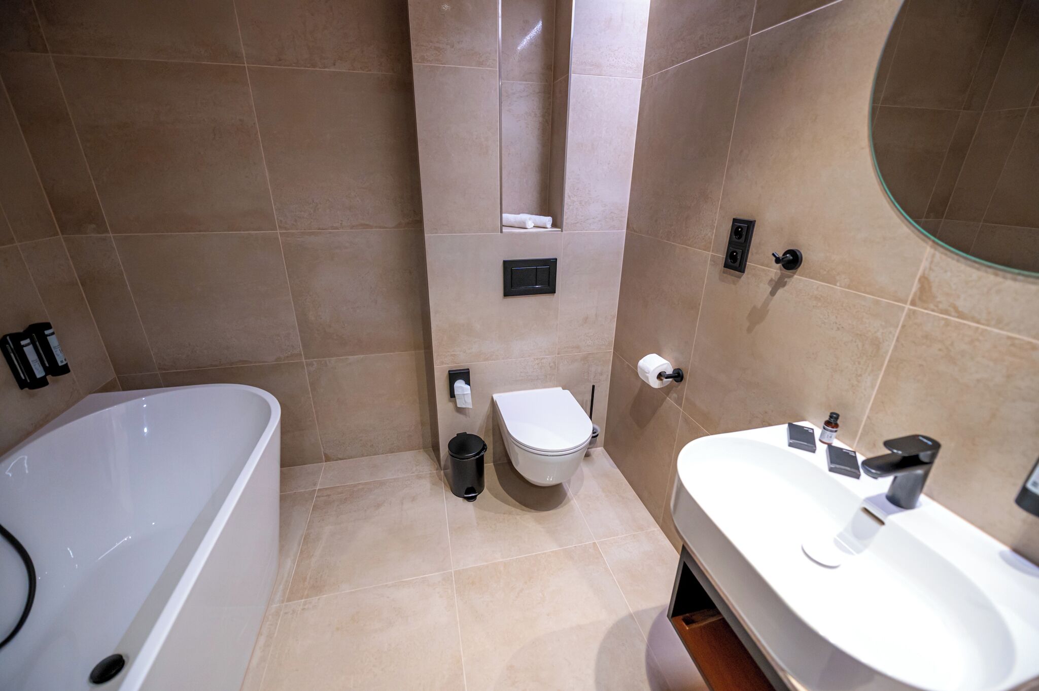 A modern bathroom with a bathtub, toilet, and sink.
