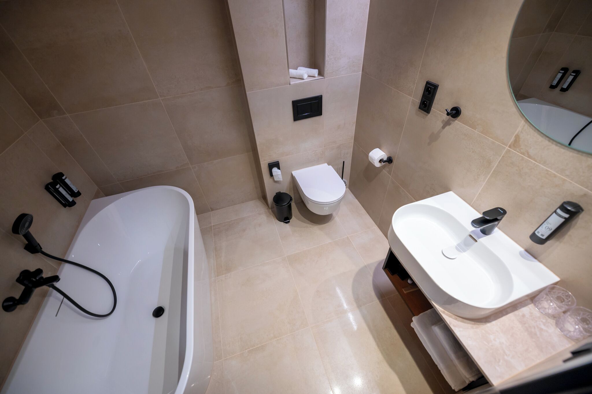 Et moderne badeværelse med badekar, toilet og håndvask.