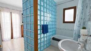 Ein Badezimmer mit Badewanne, Waschbecken und Fenster.