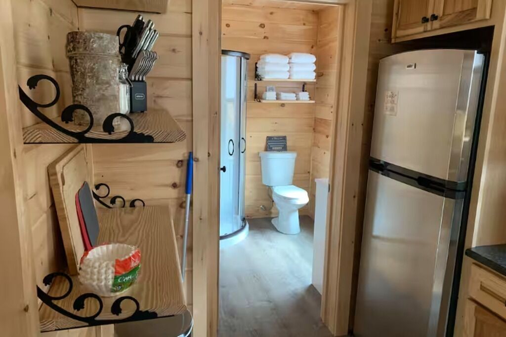 A wooden interior with a refrigerator, a sink, and a toilet.