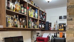 A home office with a desk, computer, and shelves of various bottles.