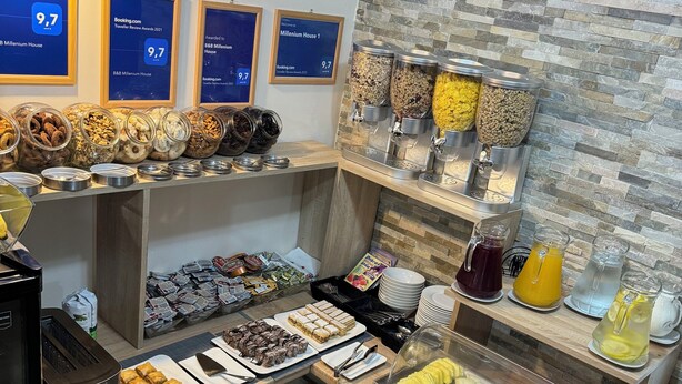 A breakfast buffet with various food items, a coffee machine, and a wall-mounted air conditioner.