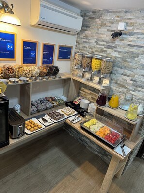 A breakfast buffet with various food items, a coffee machine, and a wall-mounted air conditioner. - Millenium House 2 (Jezerce)