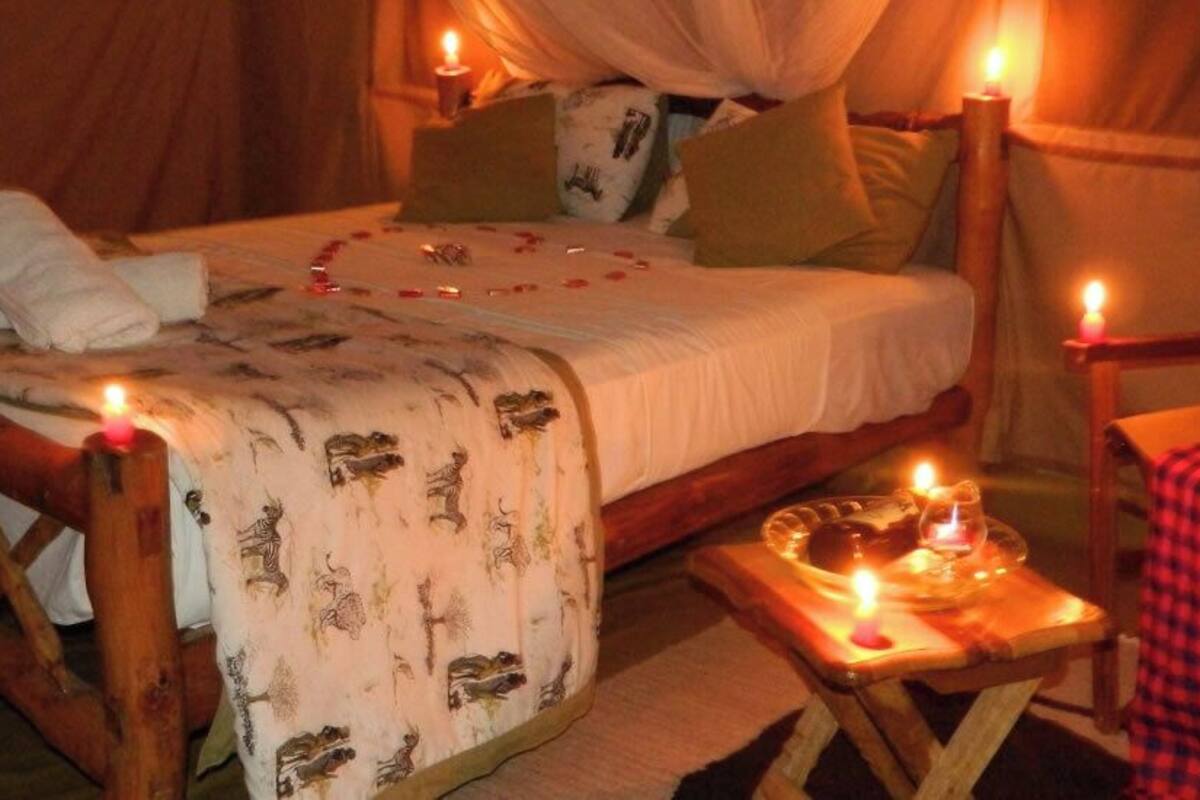 Ein gemütliches Bett mit Baldachin, ein Holzstuhl und ein kleiner Tisch mit Kerzen.