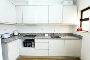 Een koelkast, een magnetron, een kookplaat, een broodrooster