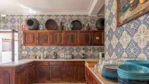 Een keuken met houten kastjes, een betegelde achterwand en een aanrecht met keukenapparatuur.