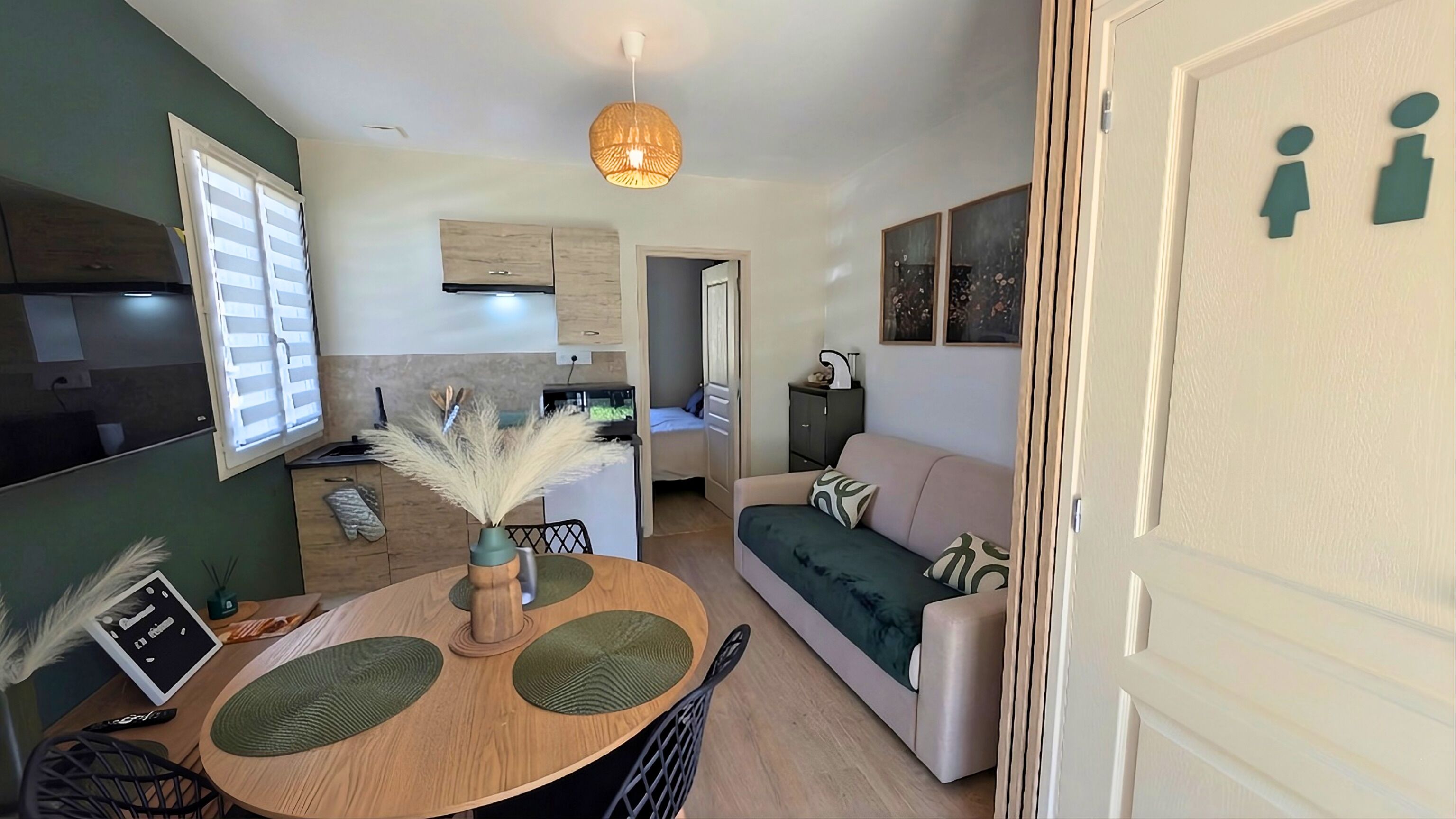 A compact living space with a dining area, kitchenette, and a sofa.
