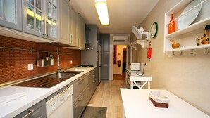 Eine moderne Küche mit Ziegelrückwand, Edelstahlgeräten und weißen Schränken.