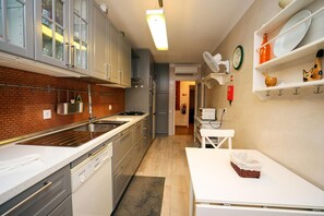 A modern kitchen with a brick backsplash, stainless steel appliances, and white cabinetry. - C27 - Torraltinha Way Apartment (Lagos)