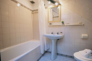 A bathroom with a bathtub, a sink, a toilet, and a shower area. - B46 - Belavista Torraltinha Flat (Lagos)