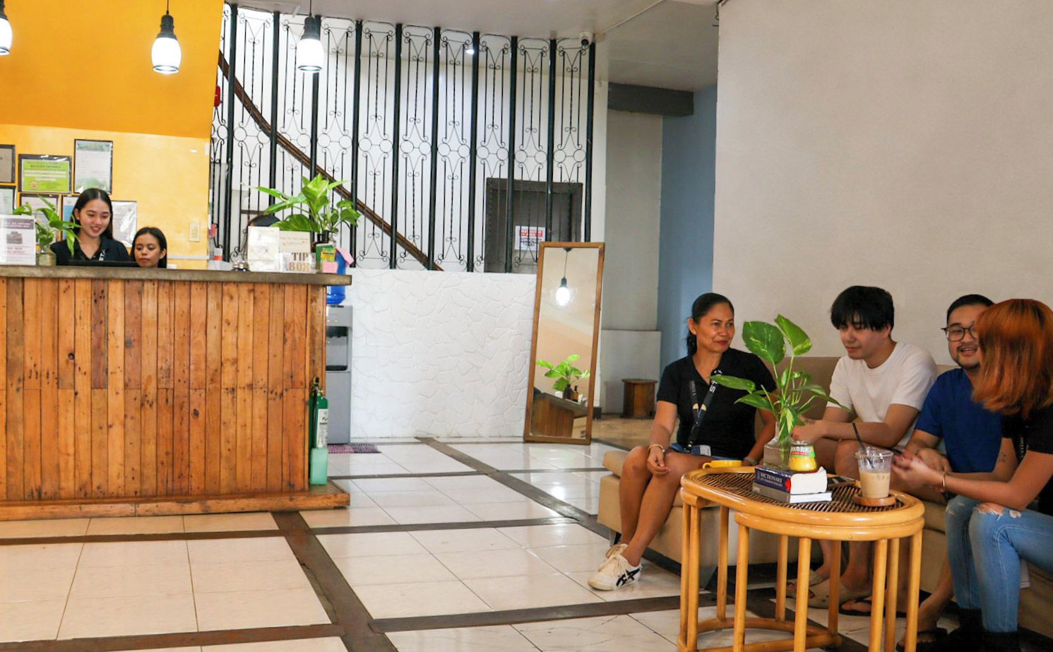 A reception area with a wooden counter, a staircase, and a seating area with a table and chairs.