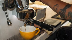 A coffee machine dispensing coffee into a yellow cup.