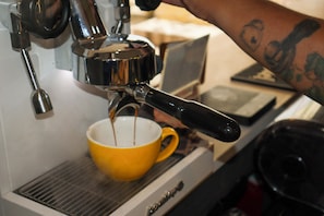 A coffee machine dispensing coffee into a yellow cup.