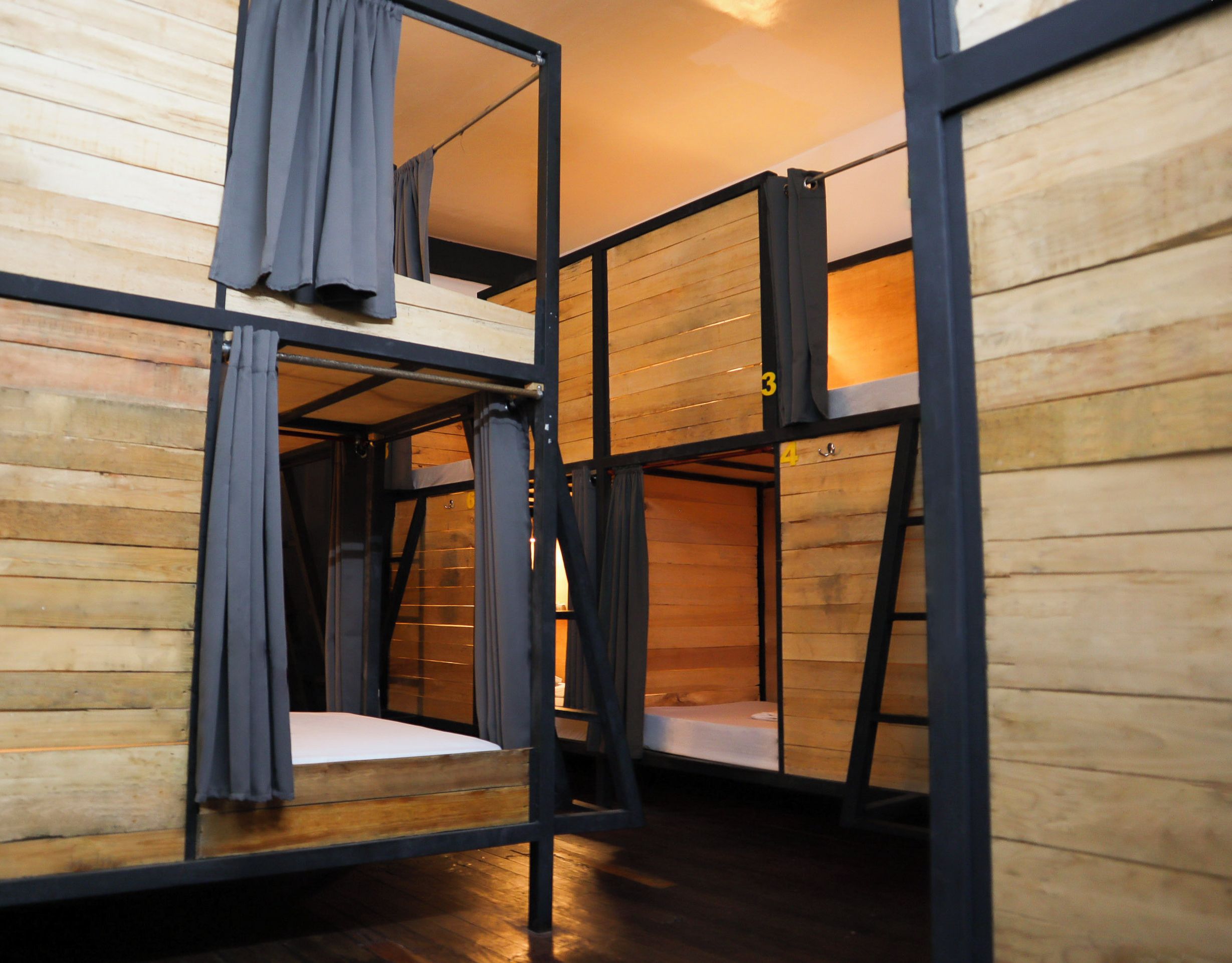 Ein Schlafzimmer mit Stockbetten, Holzwänden und Metallgestellen.