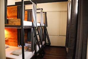 A bunk bed room with a wooden wall and a white door.