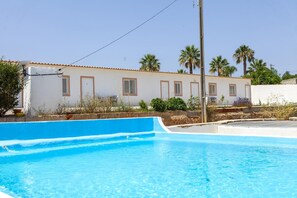 Une piscine avec un bâtiment blanc en arrière-plan.