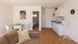 A compact living space with a dining area, kitchenette, and a cozy seating area. - X 06 - 1 Bed Apartment in Quinta da Ponte (Lagos)