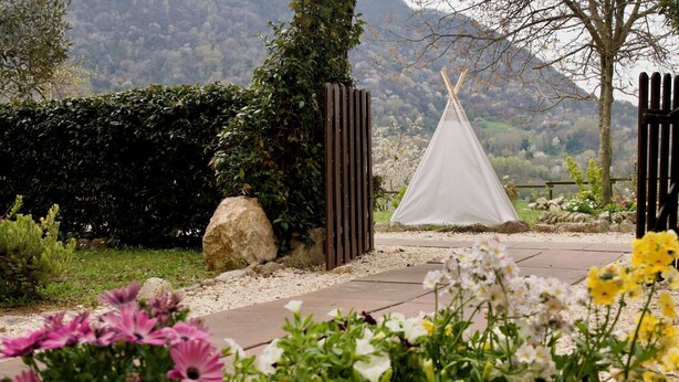 A garden pathway leading to a white tent, surrounded by greenery and flowers. - Happy Corner - The Home for Outdoor Lovers - (Veneto)