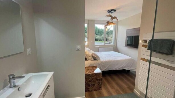 Un baño moderno con lavamanos, espejo y ducha.
