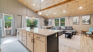 Une cuisine spacieuse dotée de meubles en bois, d’un plan de travail en granit et d’un coin repas avec une table et des chaises.