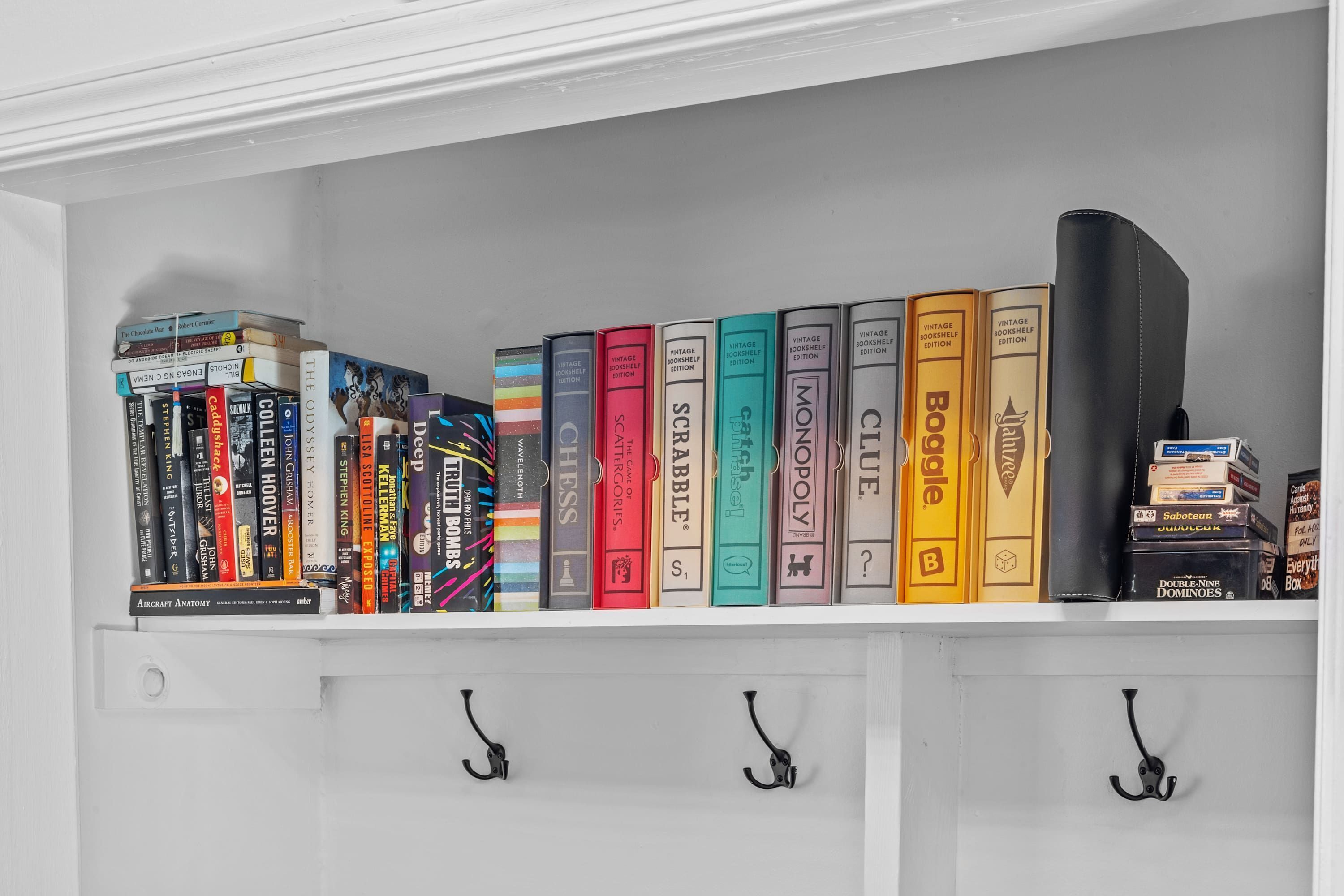 A bookshelf with a variety of books, including titles like 'The Odyssey' and 'Monopoly.'