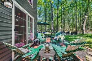 A patio with green Adirondack chairs, a table, and a decorative vase. - Cozy Poconos Retreat Hot Tub Dog Friendly Firepit (Pocono Lake)