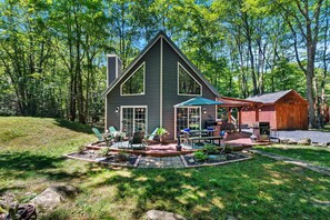 A cabin with a deck, outdoor seating, and a small shed. - Cozy Poconos Retreat Hot Tub Dog Friendly Firepit (Pocono Lake)