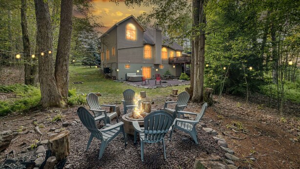 A rustic cabin with a fire pit, outdoor seating, and a view of the house. - Spa Retreat With Hot Tub Sauna and Game Rooms (Lake Harmony)