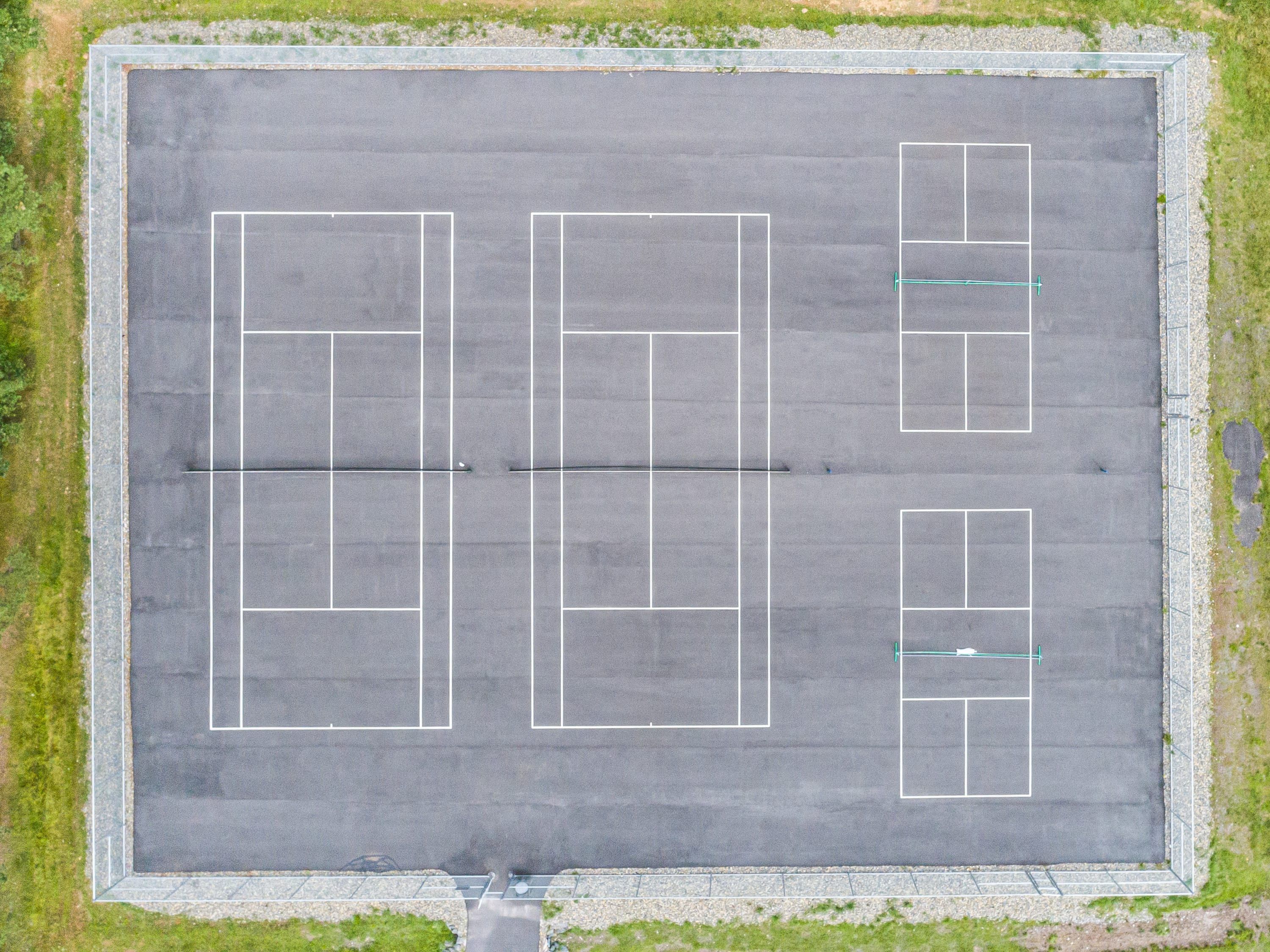 Vista aérea de un estacionamiento con múltiples espacios delimitados y un separador central.