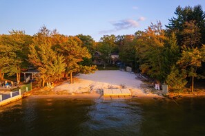 A lakeside property with a dock, a covered seating area, and a house in the background. - Fam-friendly Cabin Mins 2 Beach Ski w Hot Tub (Lake Harmony)